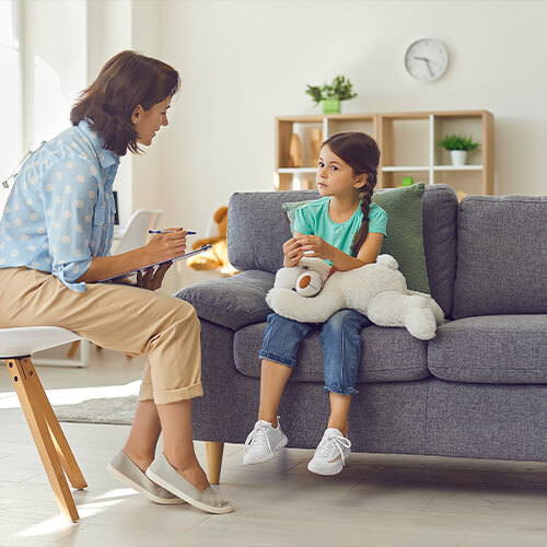 woman speaking to child sitting on the couch